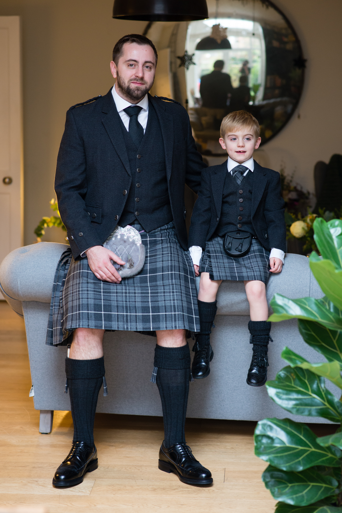 A groom and his son both wearing kilts on his wedding day